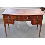 A reproduction mahogany four drawer serpentine front writing table with leather lined top, width