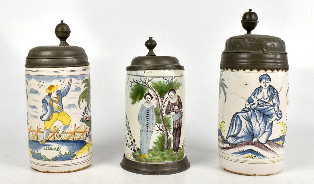 Three 18th century German faïence steins with hinged pewter covers, one decorated with figures