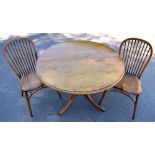 STEWART LINFORD; a reproduction light oak extending dining table with circular top and additional