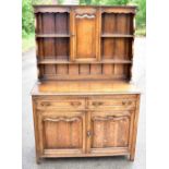 An 18th century style oak dresser, the raised back with a cupboard door, above two drawers and two