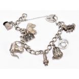 A silver charm bracelet, set with several charms including a pair of handcuffs, a teapot, etc,