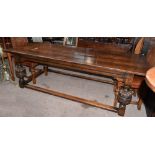 A 17th century style oak refectory dining table, the plank top with cleated ends, on carved and