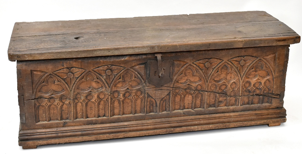 An 18th century blanket box, the hinged lid above a Gothic carved panel front, width 151cm, depth