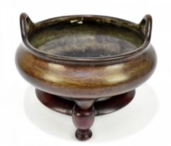 A large and rare Chinese bronze censer with simple loop handles, three tapering supports and