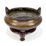 A large and rare Chinese bronze censer with simple loop handles, three tapering supports and