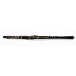 A 19th century Viennese ebony flute with white metal keys and mounts and enamel insets to either