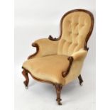 A Victorian walnut framed spoon back armchair, with front scrolling feet.