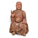 A large 17th/18th century Chinese carved wooden figure of Buddha, seated with right hand raised