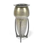 LIBERTY & CO; a hammered pewter rocket vase, with three pierced swept supports, indistinctly stamped