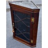 A Georgian oak hanging corner cupboard with astragal glazed door enclosing shaped shelves, with H-