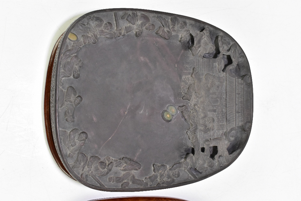 A Chinese Qing Dynasty duan ink stone, with incised details to the underside, and with wooden base - Image 2 of 4