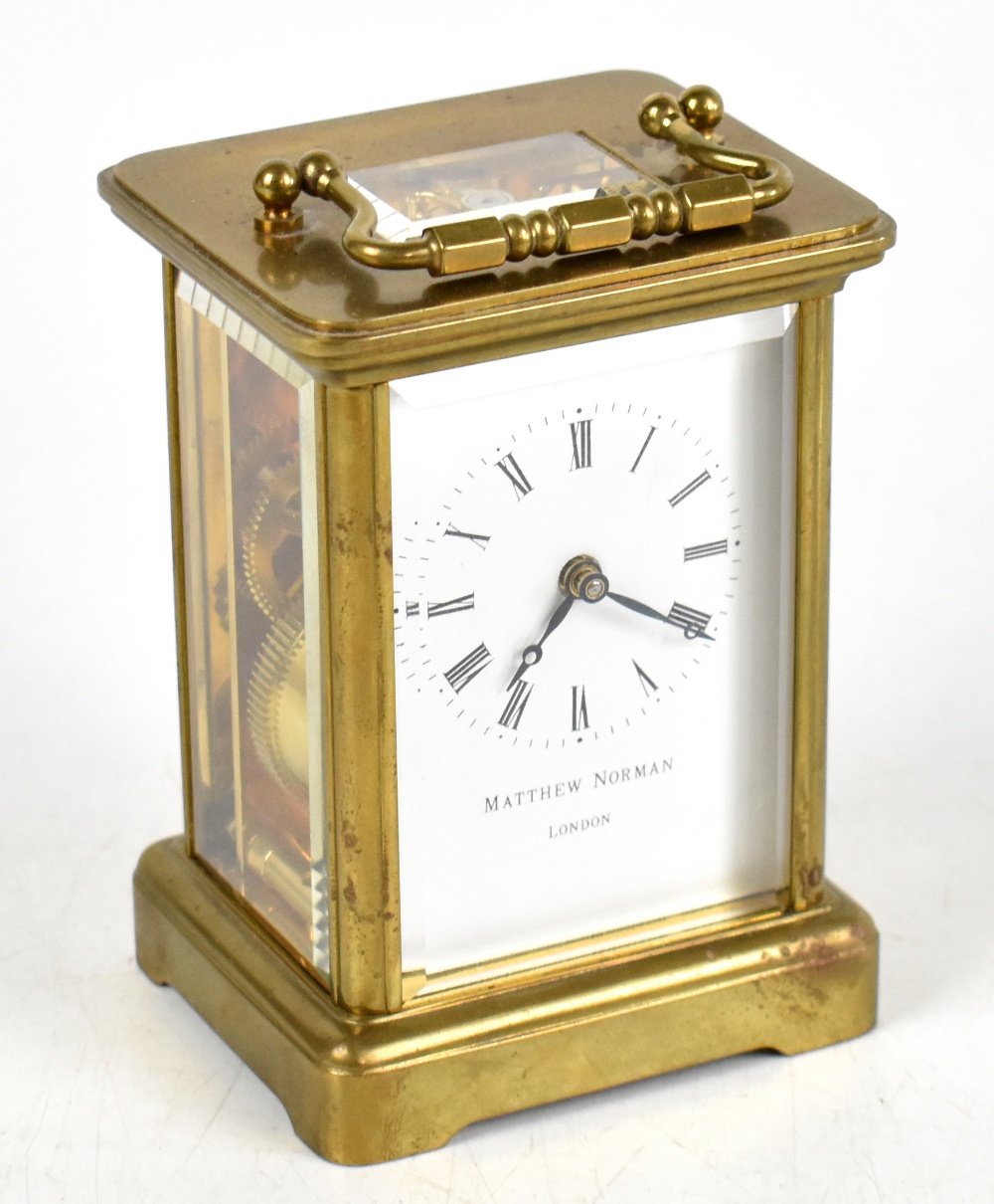 MATTHEW NORMAN; a modern lacquered brass carriage time piece, the enamel dial with Roman numerals,