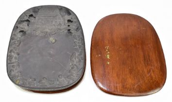 A Chinese Qing Dynasty duan ink stone, with incised details to the underside, and with wooden base
