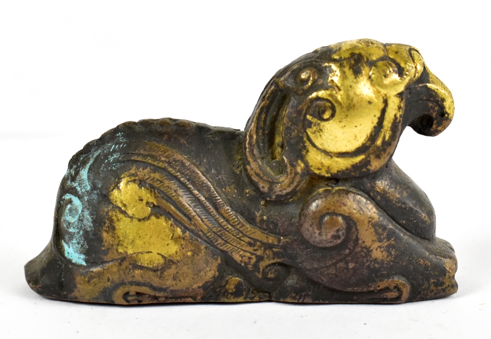 A small Chinese gilt bronze figure of a recumbent animal/mythical beast, probably 17th century,