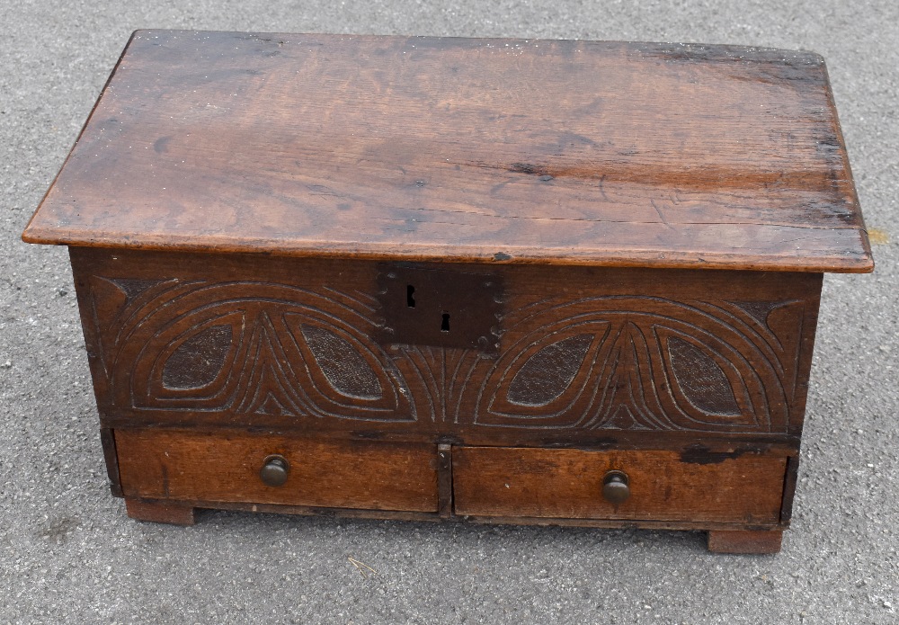 *****WITHDRAWN***** An 18th century oak coffer bach, the hinged lid above carved detail to the