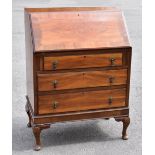 An early 20th century walnut bureau, the fall front enclosing fitted interior, above three