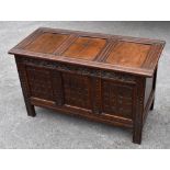 An oak coffer, the hinged three panel lid above a carved front, width 104cm, depth 46cm, height