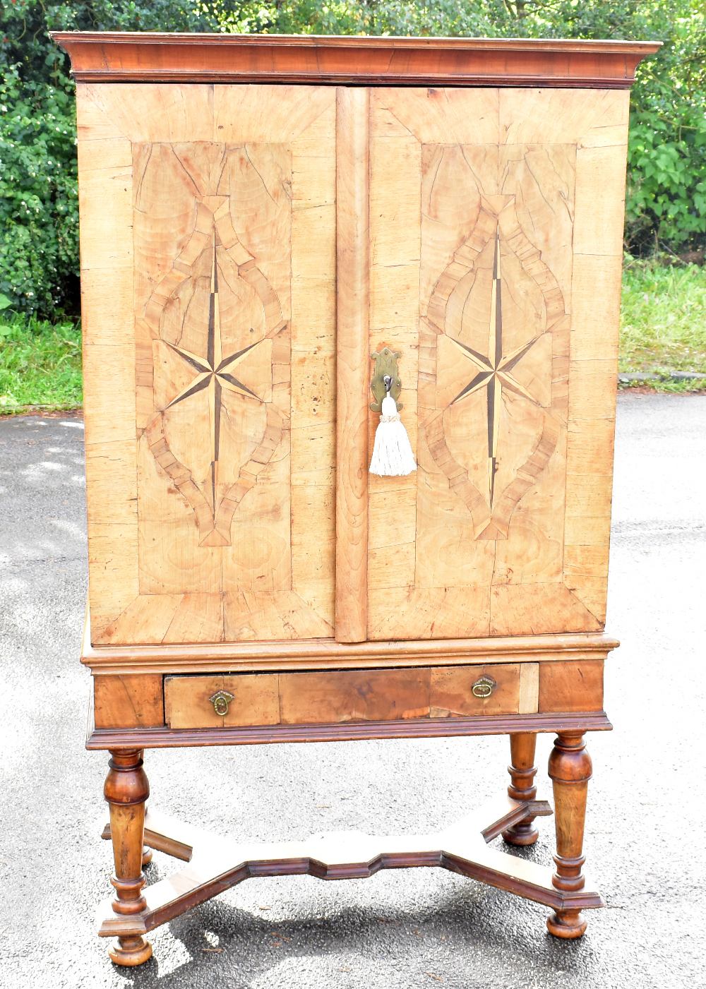 A late 18th century and later German inlaid walnut cabinet on stand, with two doors enclosing a