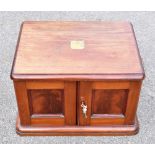 A Victorian mahogany table canteen of cutlery, the twin panelled doors enclosing four drawers