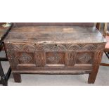 An 18th century oak coffer with carved and panelled front, on block feet, width 118cm, depth 45cm,