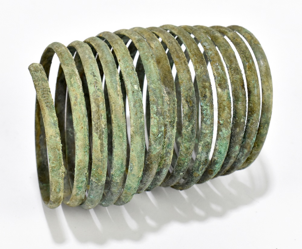 A Bronze Age bronze bracelet, formed of a spiral in a single piece with twelve coils, circa 8th/