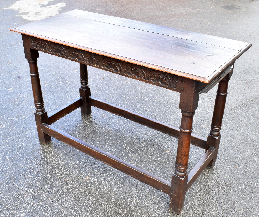 An 18th/19th century oak hall/side table with rectangular top above carved frieze with initials '