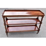 A Victorian mahogany three tiered buffet, raised on turned and block supports to substantial brass