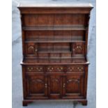 A reproduction oak dresser, the boarded rack with drawers and doors above a three drawer base with