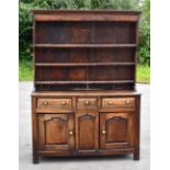 An 18th century oak dresser with boarded plate rack back, above three drawers and two cupboard