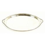 WALKER & HALL; a George V hallmarked silver twin handled tray with bead decorated rim, pierced