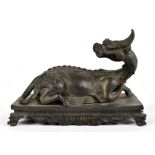 A late 19th/20th century Chinese bronze model of a kylin, the mythical beast modelled recumbent with