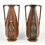 A pair of Art Nouveau copper twin handled vases, with embossed foliate detailing and decorated