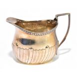 WILLIAM HUTTON & SONS; an Edward VII hallmarked silver cream jug with cast rim and gadrooned lower