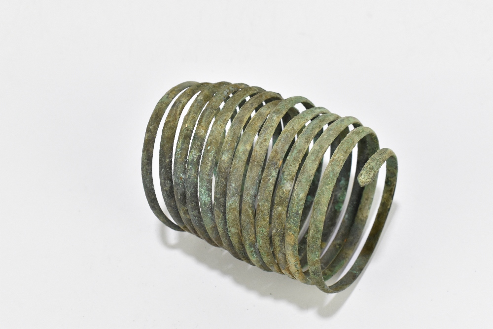 A Bronze Age bronze bracelet, formed of a spiral in a single piece with twelve coils, circa 8th/ - Bild 2 aus 2