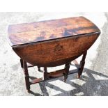 A small 19th century oak oval drop-leaf table with end drawer on turned gateleg supports, 90 x 103.