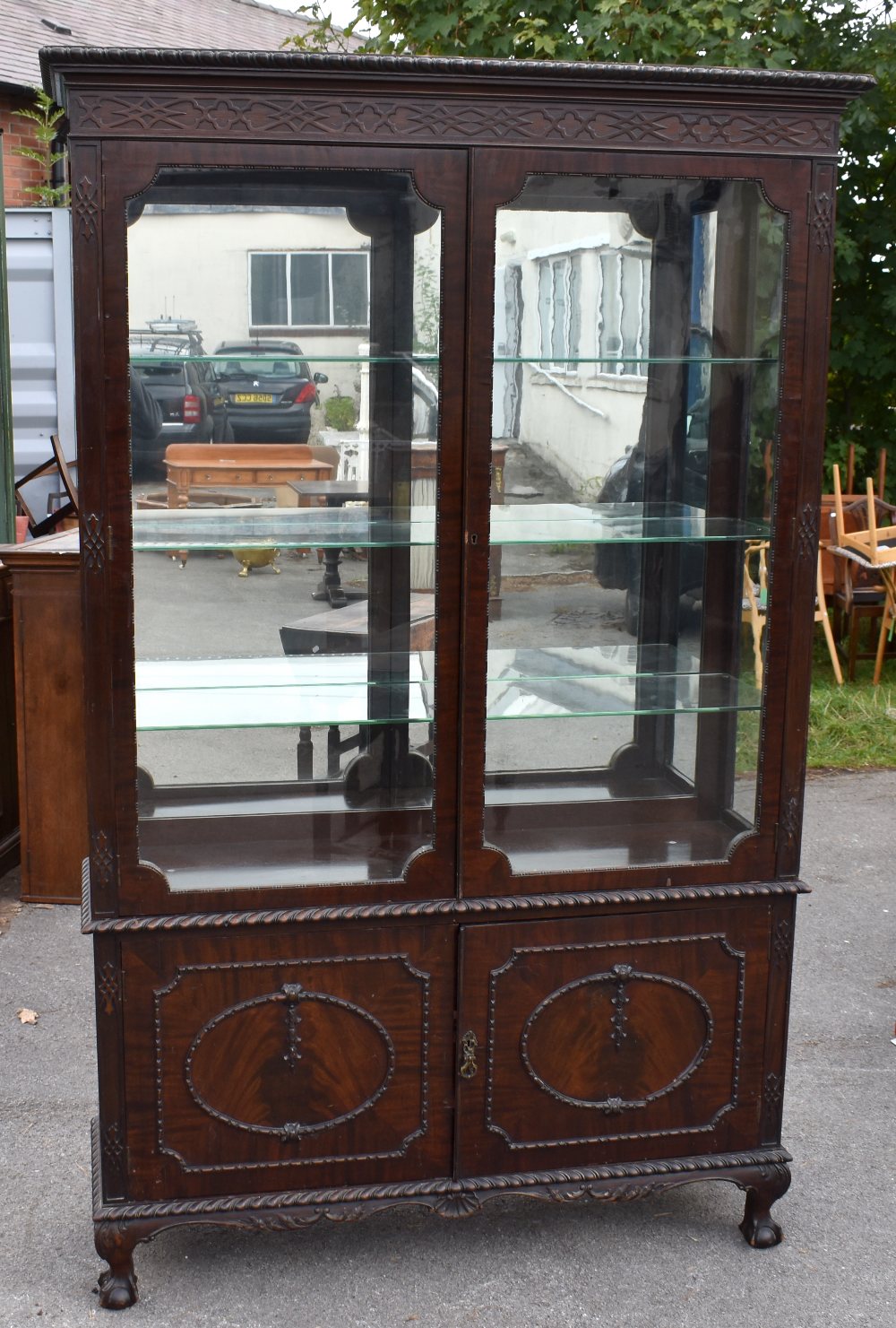 A large Edwardian mahogany display cabinet, the glazed top above pair of doors on short cabriole