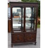 A large Edwardian mahogany display cabinet, the glazed top above pair of doors on short cabriole