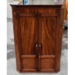 A 19th century mahogany and boxwood strung two door wall hanging corner cupboard with two internal