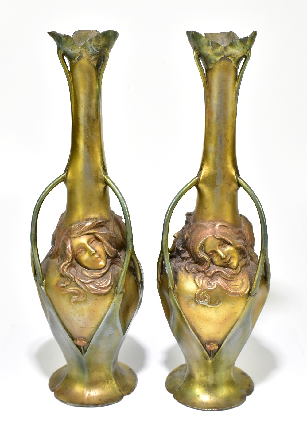 A pair of Art Nouveau bronzed metal three handled vases cast with Art Nouveau maidens and floral