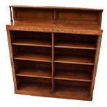 A late Victorian walnut open bookcase, the raised panelled back above two sets of open shelves, with