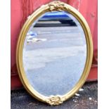 A decorative gilt framed oval bevelled wall mirror, 80 x 60cm.