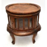 A modern stained hardwood coffee table/cabinet of oval form with glazed door and detachable top,