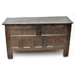 A late 17th century carved oak coffer, with panelled front on stile feet, height 77.5cm, width