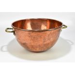 A copper and brass twin handled toffee pan, width 58cm.