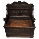 An early 20th century small carved oak settle with hinged seat, width 91cm, depth 44cm, height