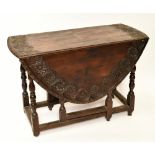 A carved oak oval drop-leaf table with end drawer on turned gateleg supports, width 102cm.Additional