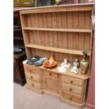 An old pine dresser with plate rack back, the boarded back with two fixed shelves above the base