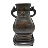 A 17th century Chinese bronze Hu vase with twin handles and band of incised decoration, unmarked,