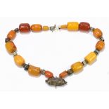 A single strand of amber beads with white metal spacers, length 55.5cm.