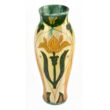 DELLA ROBBIA; a slender vase thrown by Charles Collins, and decorated with stylised flowers by